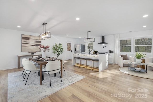 dining area with light wood-type flooring and recessed lighting