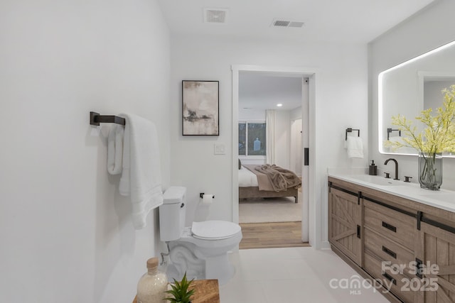 full bathroom with tile patterned flooring, toilet, connected bathroom, a sink, and double vanity