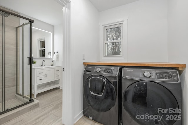 laundry room with laundry area, baseboards, independent washer and dryer, and a sink