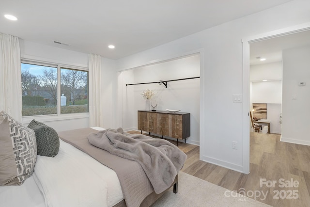 bedroom featuring light wood-style floors, baseboards, visible vents, and recessed lighting