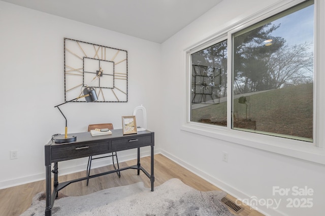 office with baseboards, visible vents, and wood finished floors