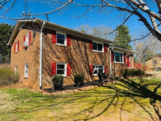 view of front of property featuring brick siding and a front lawn