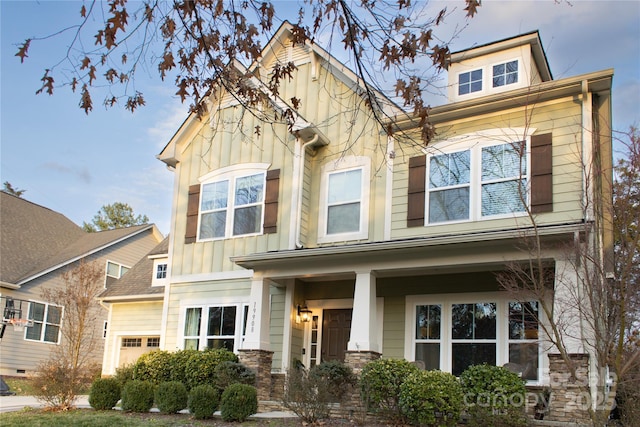 view of front of home featuring an attached garage, a porch, and board and batten siding