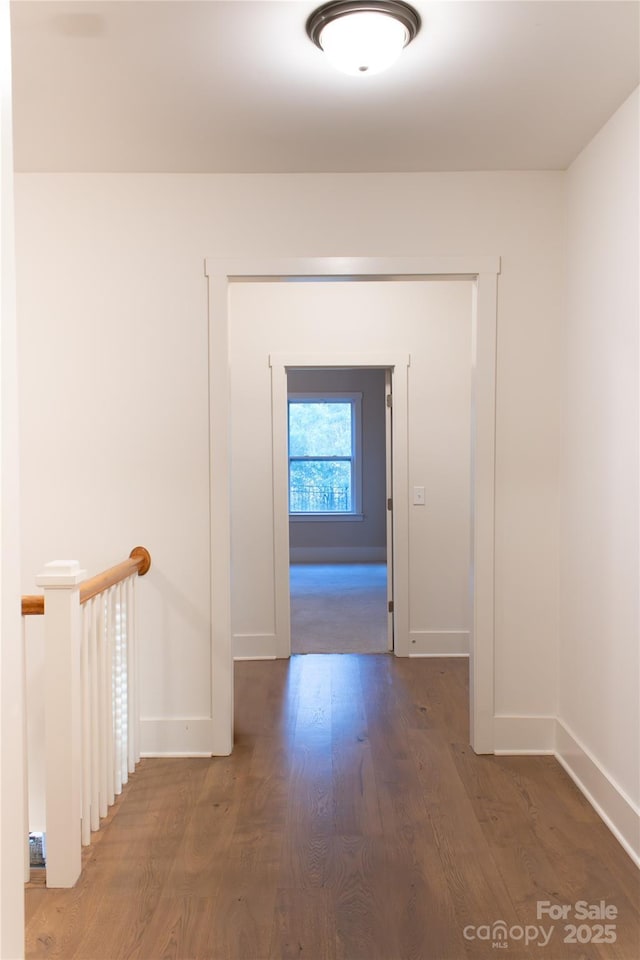 hallway with baseboards and wood finished floors