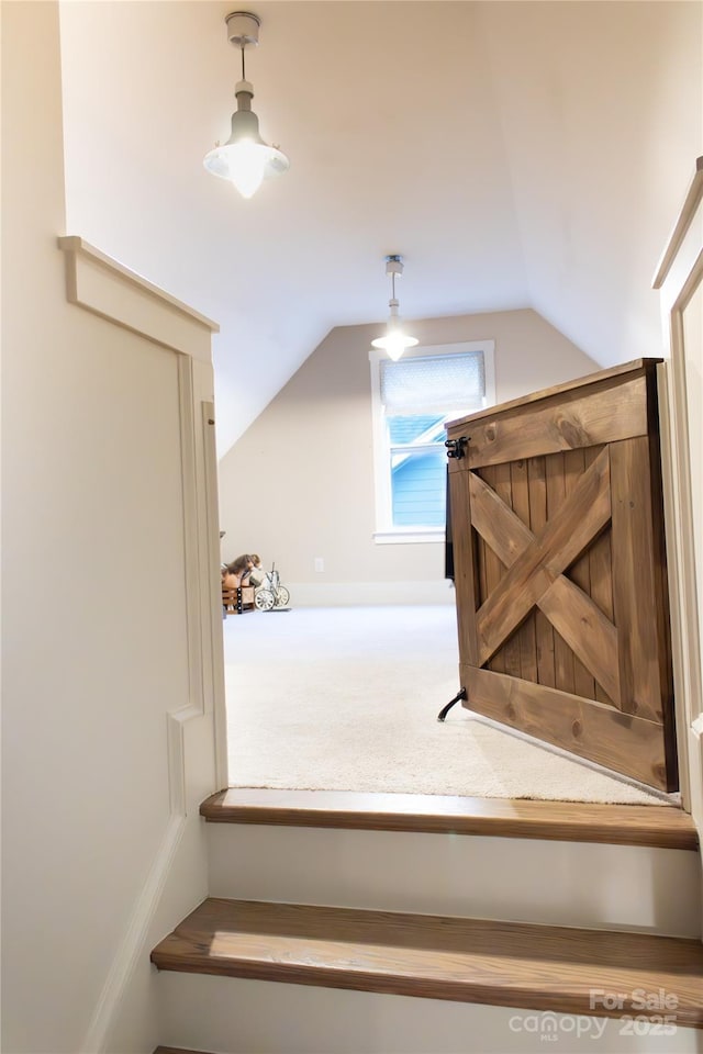 stairs with lofted ceiling and carpet