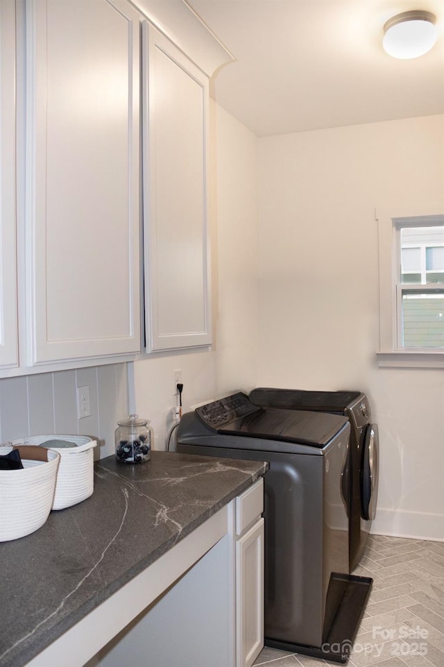 laundry area featuring cabinet space, baseboards, and washer and clothes dryer