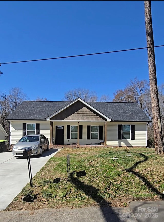 view of front of home with a front yard and concrete driveway