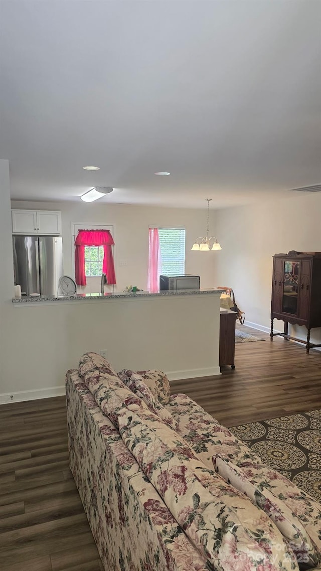 bedroom with baseboards, freestanding refrigerator, and dark wood-style floors