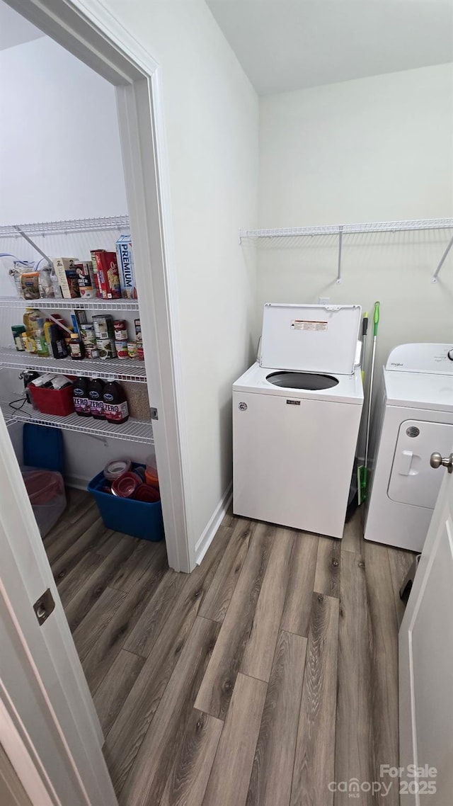 washroom with laundry area, washing machine and dryer, and wood finished floors