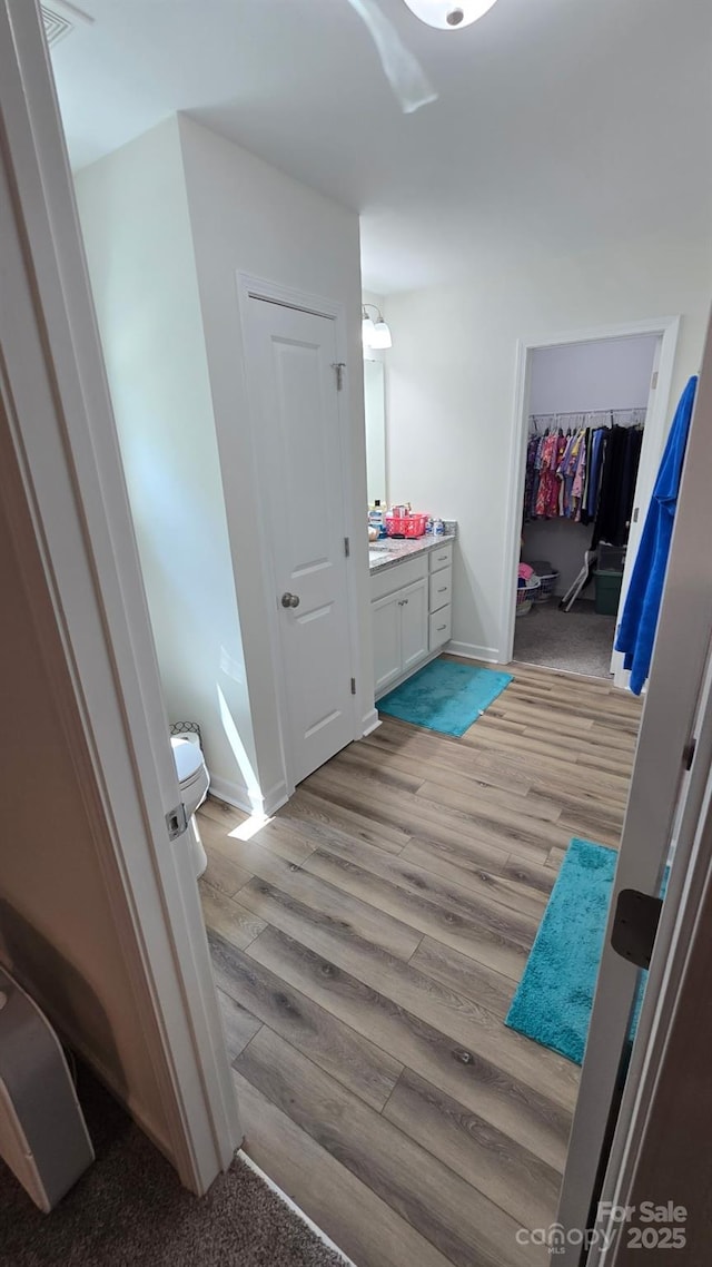 bathroom featuring vanity, baseboards, toilet, and wood finished floors
