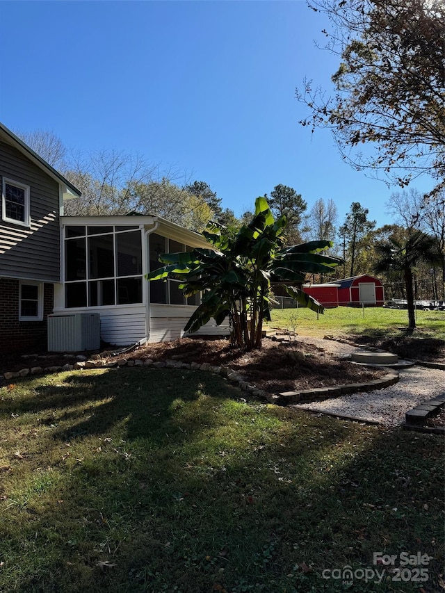 view of yard with central AC unit and a sunroom