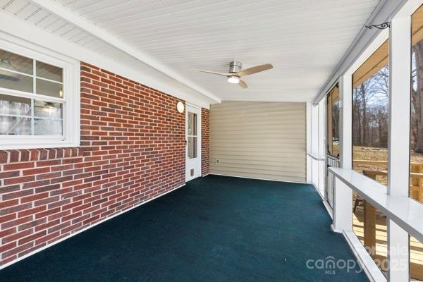 unfurnished sunroom featuring ceiling fan