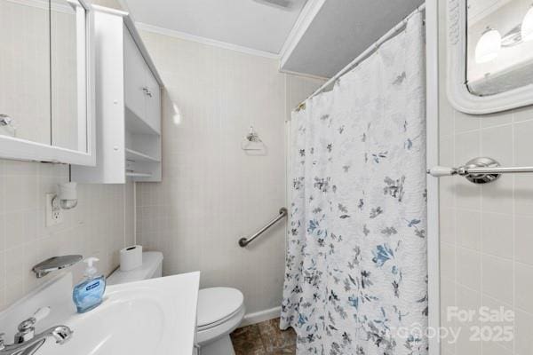 bathroom featuring toilet, tile walls, vanity, ornamental molding, and a shower with curtain