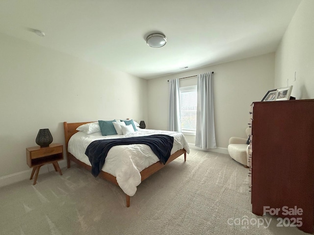 bedroom with baseboards and light colored carpet