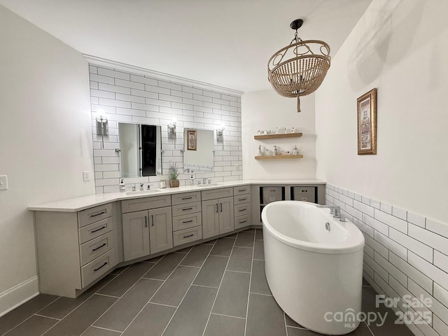 full bathroom featuring tile patterned flooring, a soaking tub, vanity, and tile walls