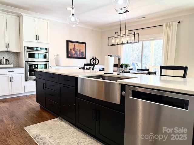 kitchen featuring dark wood finished floors, visible vents, appliances with stainless steel finishes, white cabinetry, and a sink