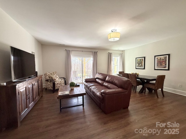 living area with baseboards and dark wood finished floors