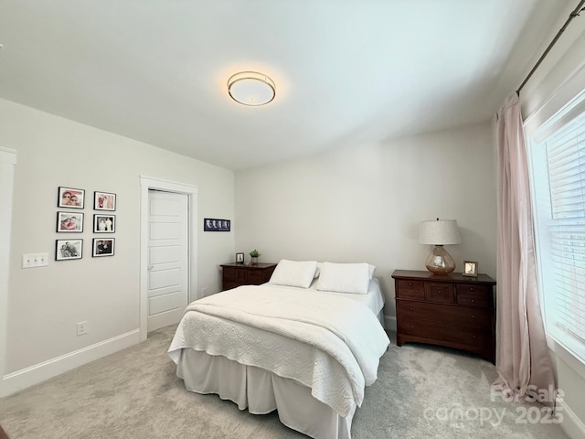 bedroom with baseboards and light colored carpet