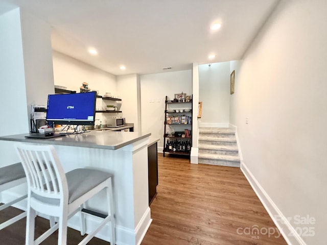 bar with visible vents, baseboards, stairway, wood finished floors, and recessed lighting