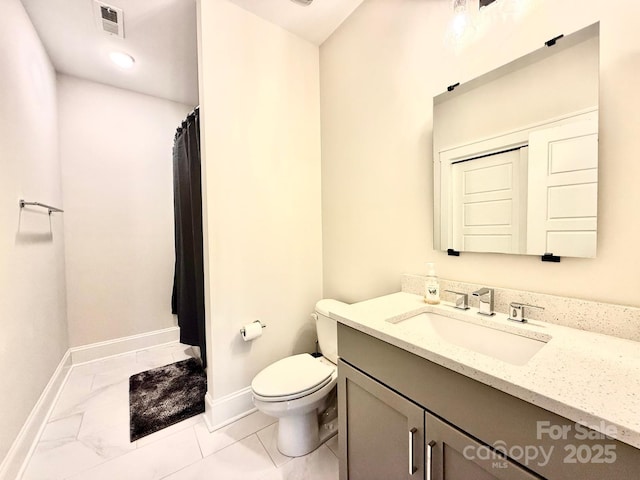 bathroom with toilet, vanity, visible vents, and baseboards