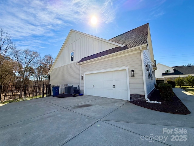 view of property exterior with driveway, a garage, roof with shingles, fence, and central air condition unit