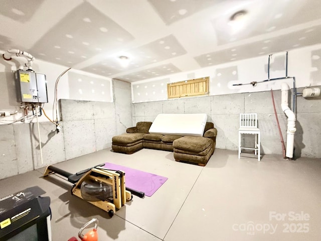 living room featuring finished concrete flooring and tankless water heater