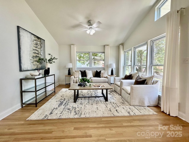 living room with high vaulted ceiling, ceiling fan, baseboards, and wood finished floors