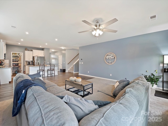 living area with ceiling fan, recessed lighting, visible vents, light wood-style floors, and baseboards