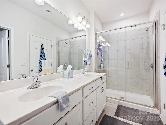 bathroom with a stall shower, visible vents, a sink, and tile patterned floors