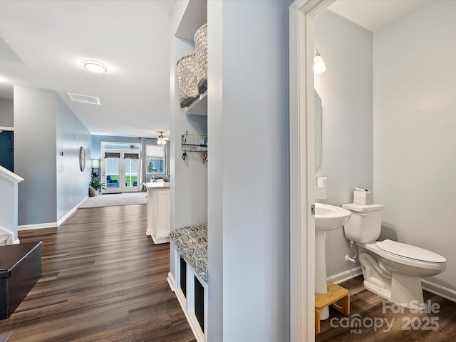 hallway with dark wood-type flooring and baseboards