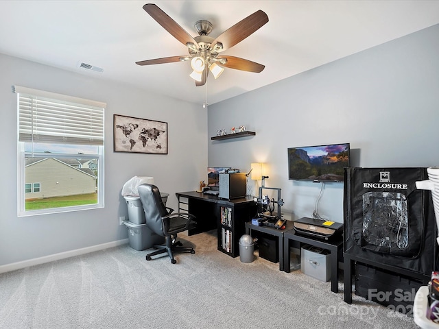 office space with a ceiling fan, carpet flooring, visible vents, and baseboards