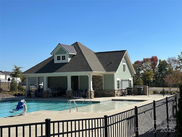 community pool with a patio area and fence