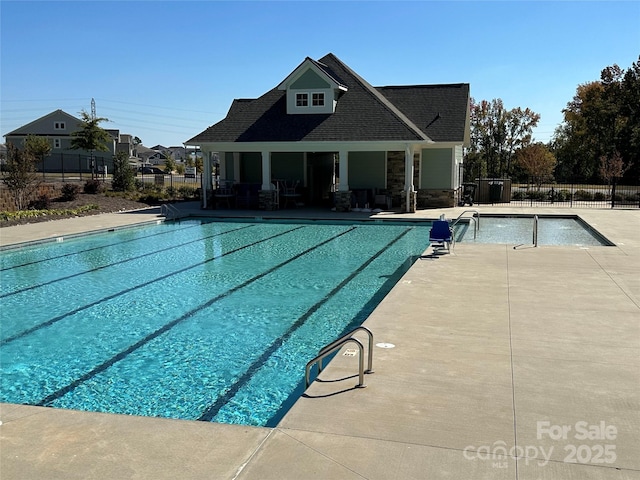 community pool featuring a patio and fence