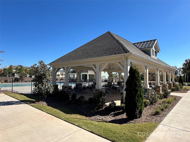 view of property's community featuring a pool, fence, a gazebo, and a patio