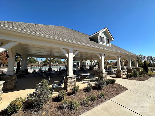 surrounding community with a patio area, a swimming pool, fence, and a gazebo