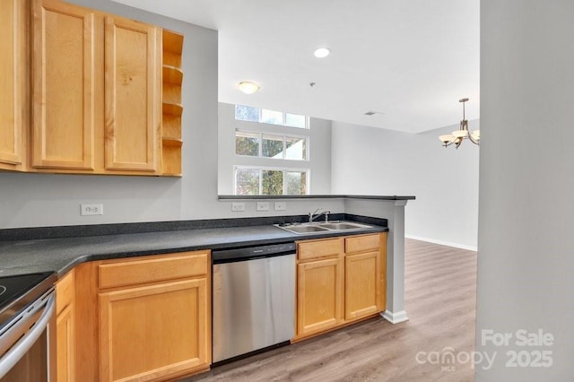 kitchen featuring light wood finished floors, open shelves, dark countertops, appliances with stainless steel finishes, and a sink