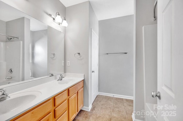 bathroom with double vanity, washtub / shower combination, toilet, and a sink