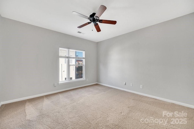 unfurnished room with ceiling fan, carpet, visible vents, and baseboards