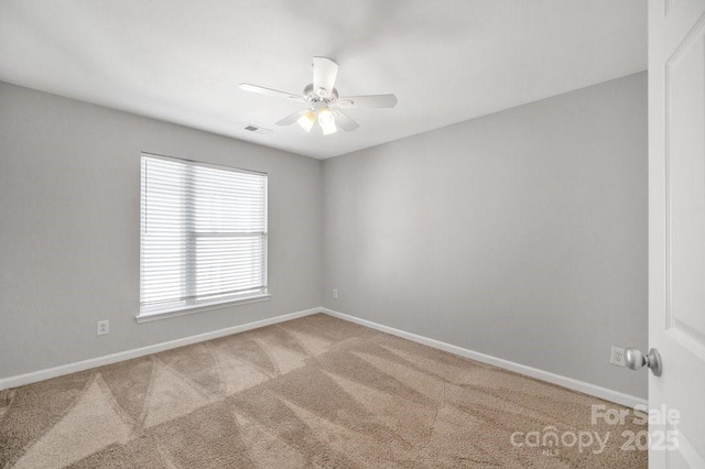 empty room with light carpet, ceiling fan, visible vents, and baseboards