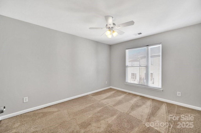 empty room featuring carpet, visible vents, baseboards, and a ceiling fan