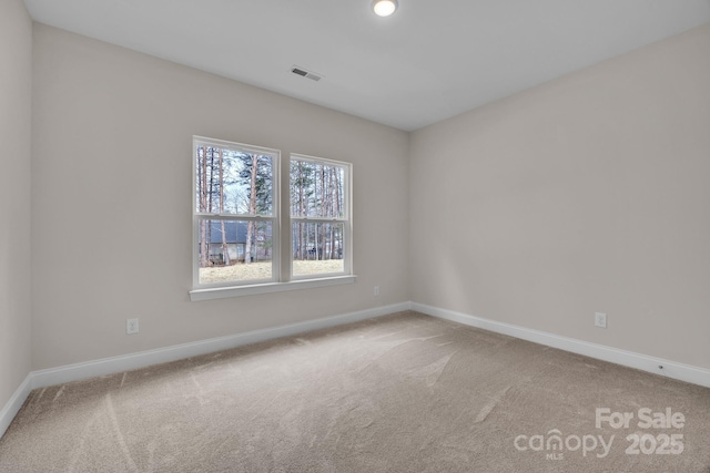 carpeted empty room with visible vents and baseboards