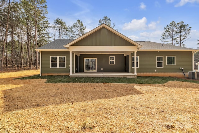 rear view of property featuring cooling unit and roof with shingles