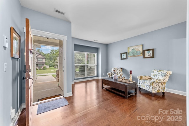 entryway with wood finished floors, visible vents, and baseboards