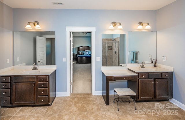 ensuite bathroom with a stall shower, visible vents, two vanities, and a sink