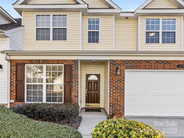 view of property with an attached garage and brick siding