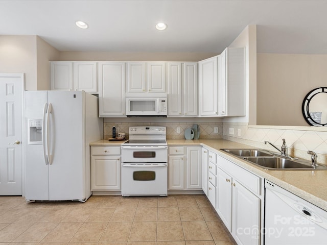 kitchen featuring white appliances, light tile patterned floors, a sink, light countertops, and tasteful backsplash