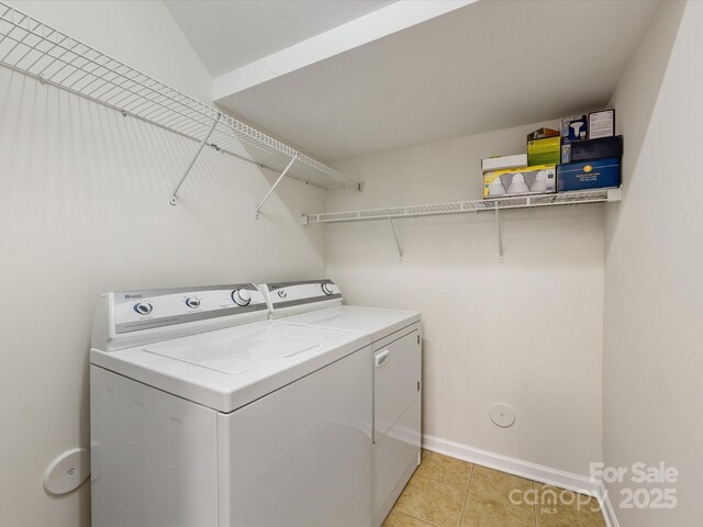 laundry area featuring laundry area, light tile patterned floors, baseboards, and independent washer and dryer