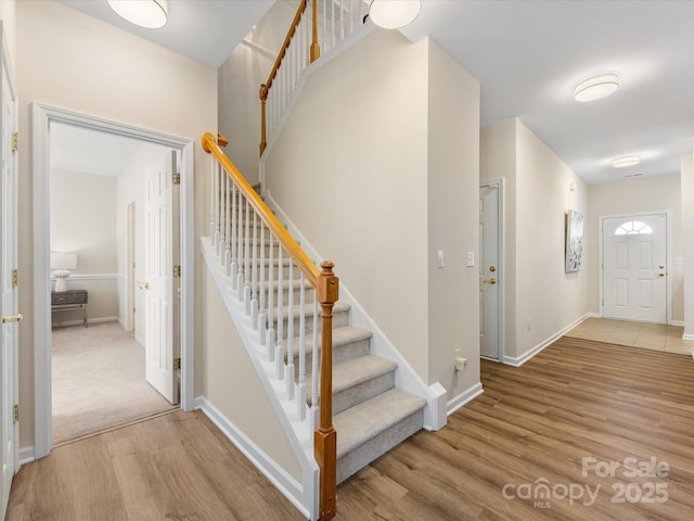 staircase with baseboards and wood finished floors