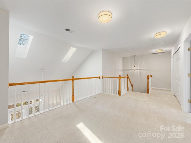 bonus room featuring vaulted ceiling with skylight, visible vents, and carpet floors