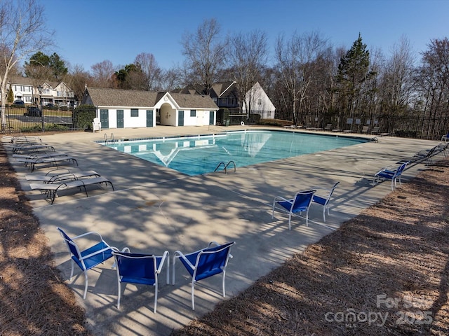 community pool with fence and a patio area